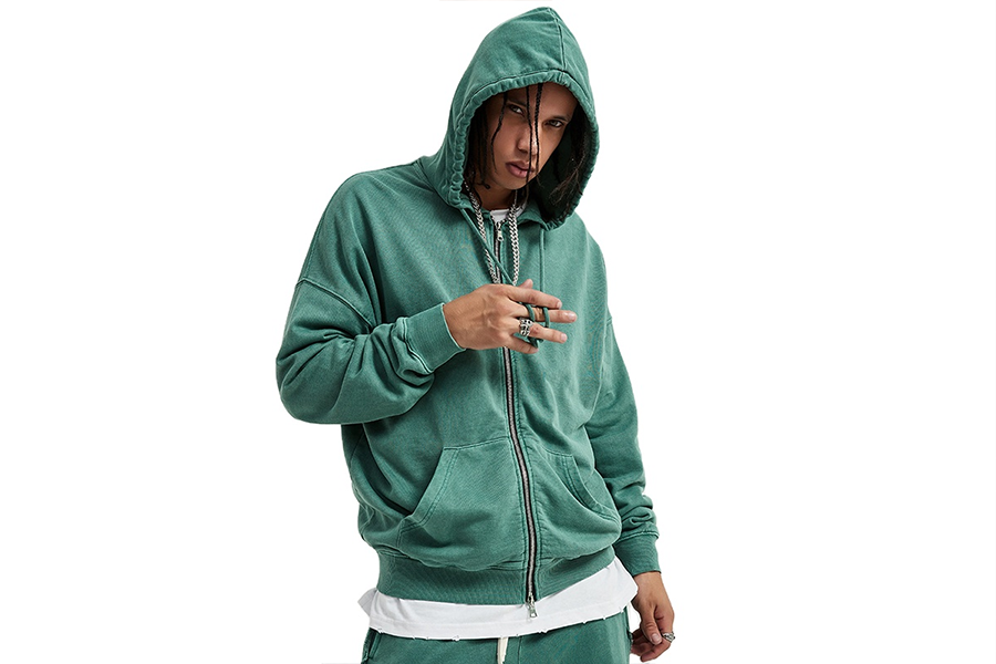 Young man wearing green zip-up hoodie with untucked shirt