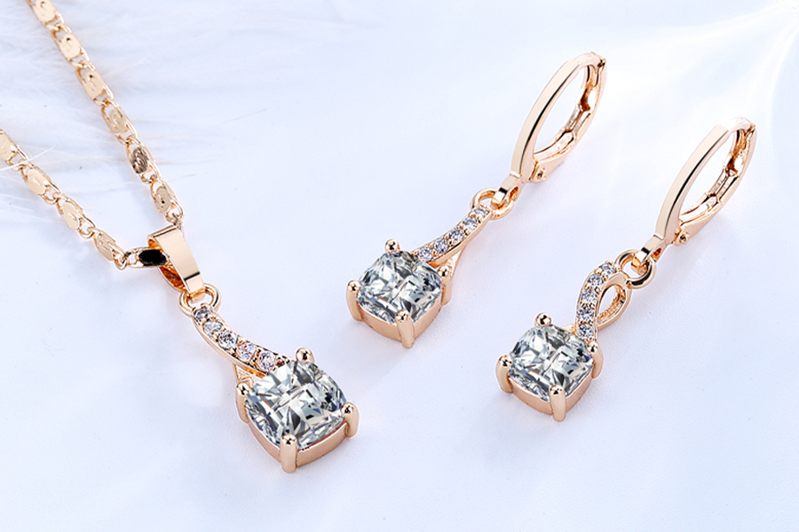Gold-plated pendant necklace and earring set with white stones