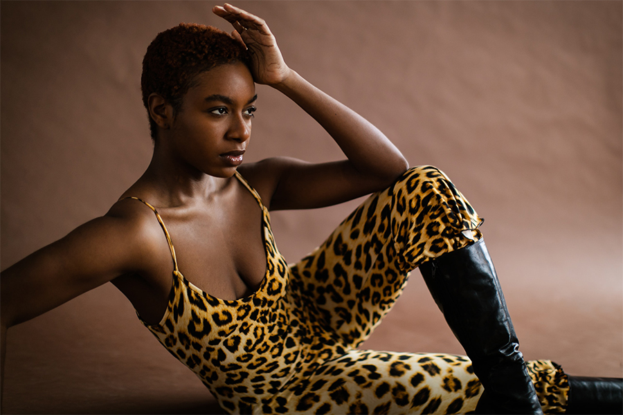 beautiful lady wearing a leopard-print bodysuit with black boots