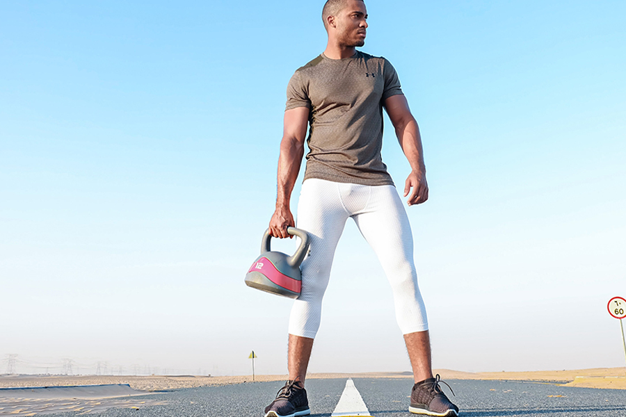 Man in light brown top and white wellness tights