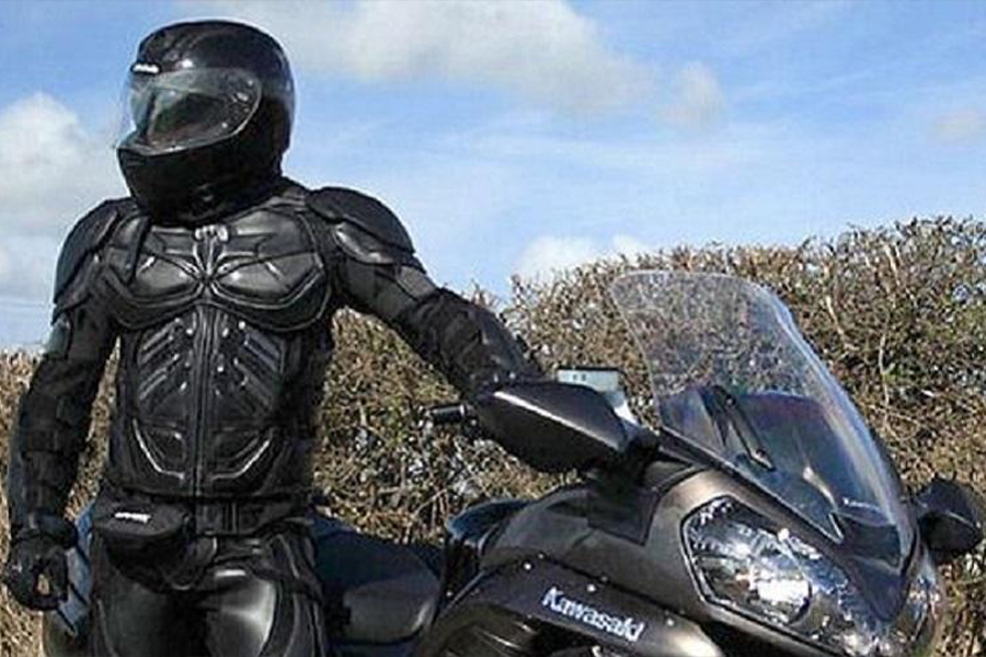 Man in body armor posing with sportbike
