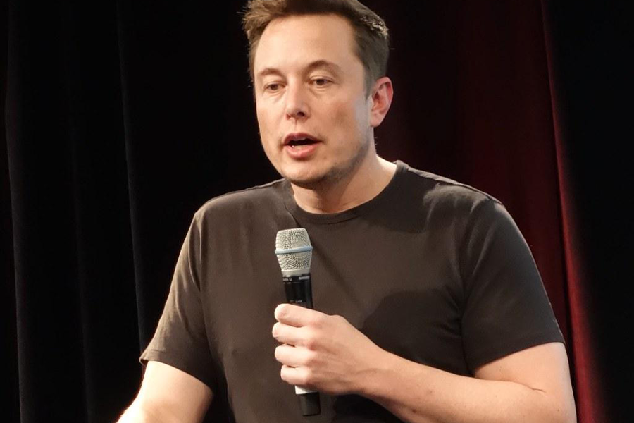 Elon musk holding a mic