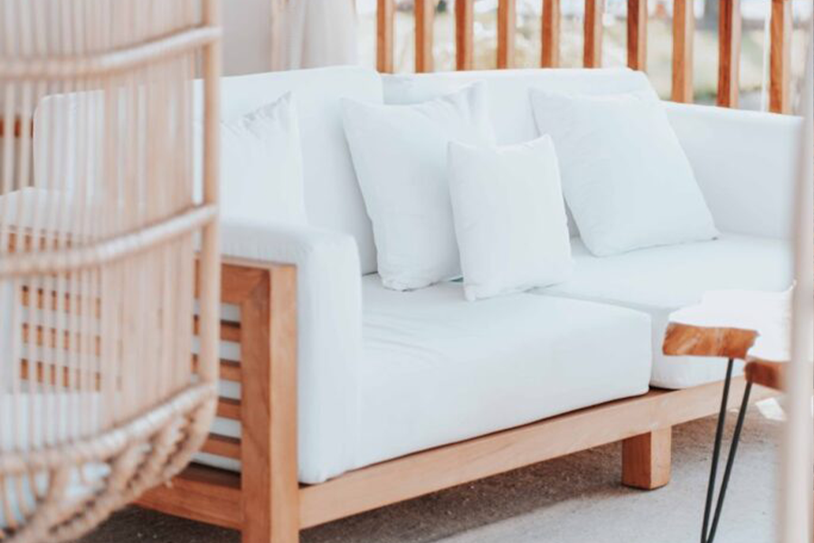 A natural wooden sofa with white cushions