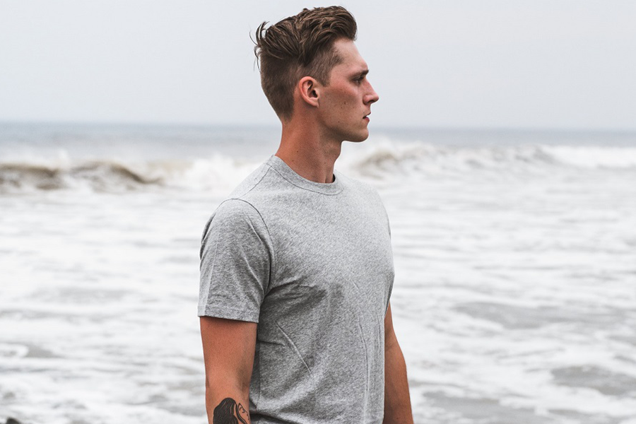 Man posing with a short sleeve shirt near the sea