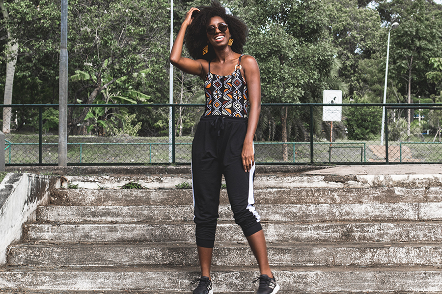 Cute black lady rocking designed-print performance vest with black trainers