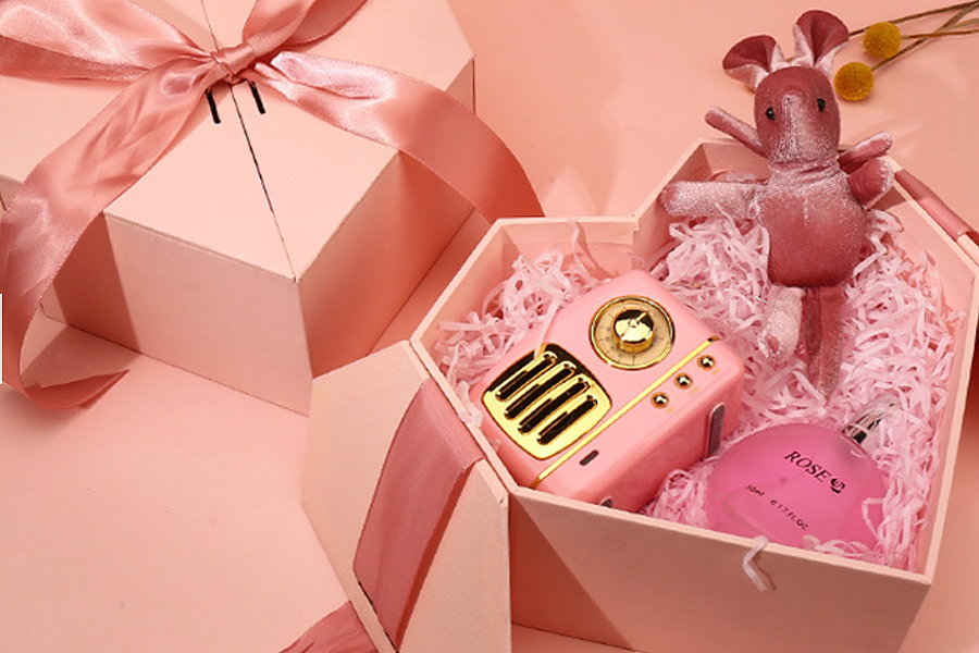 Heart-shaped gift box in baby pink containing gift items
