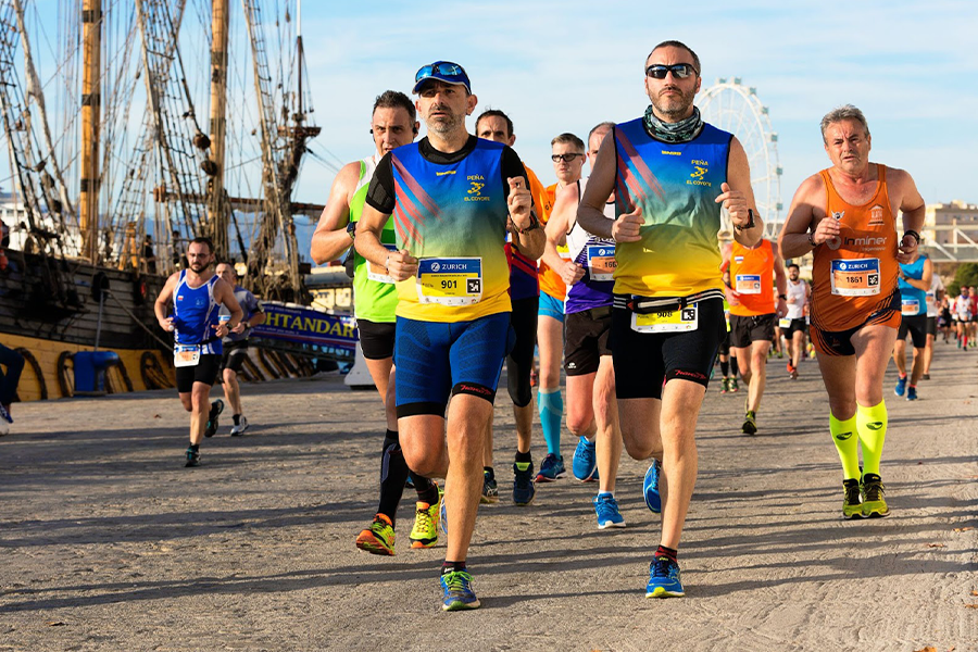 A group of men running a marathon next to ship