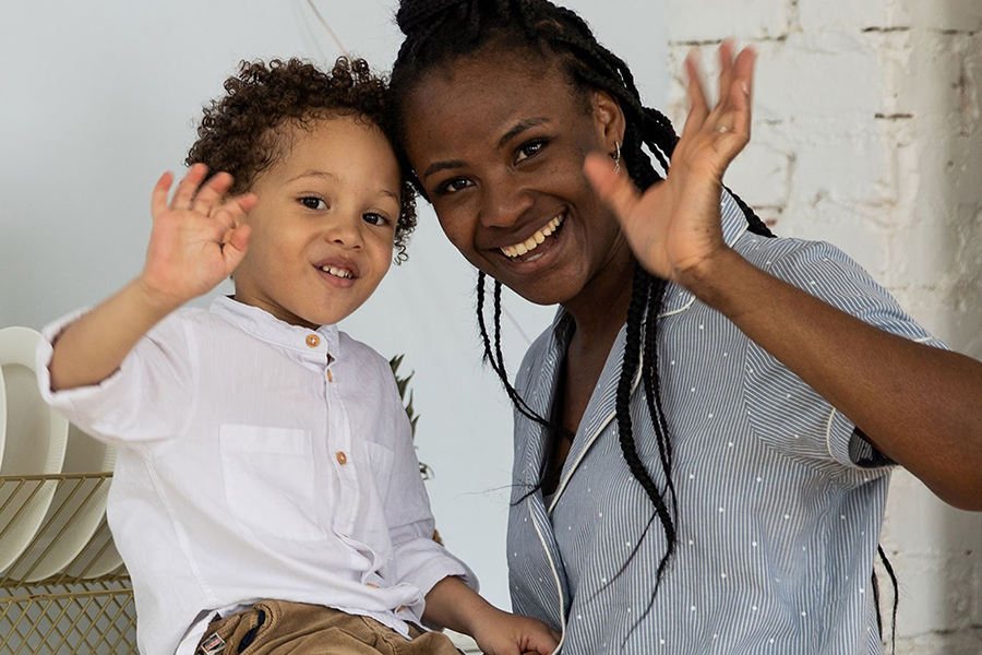 Toddler with white linen shirt posing with his mom