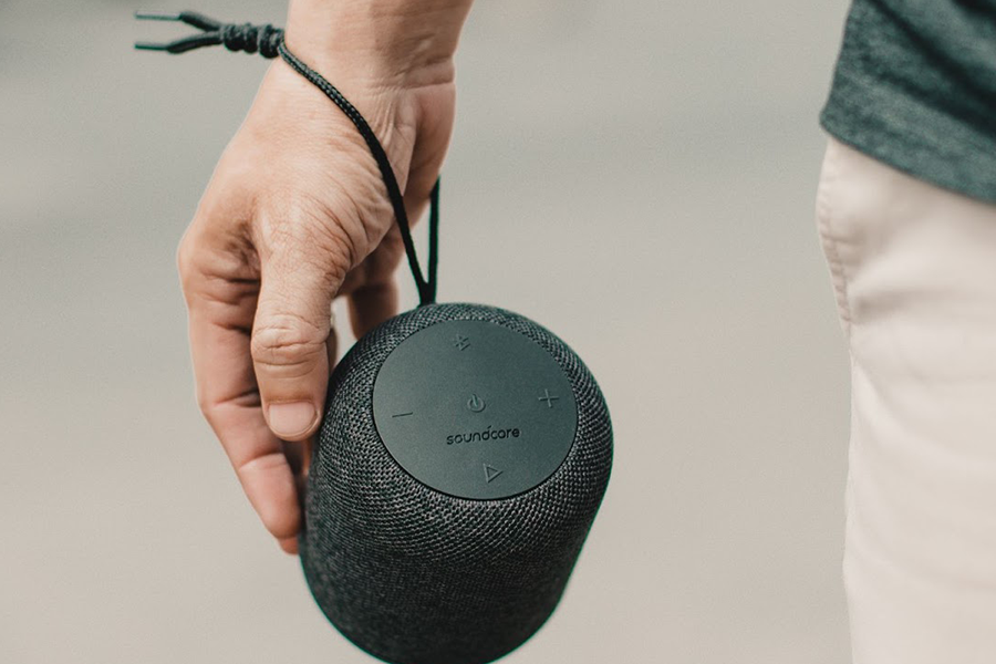 Portable and wireless Bluetooth speaker being carried by its user