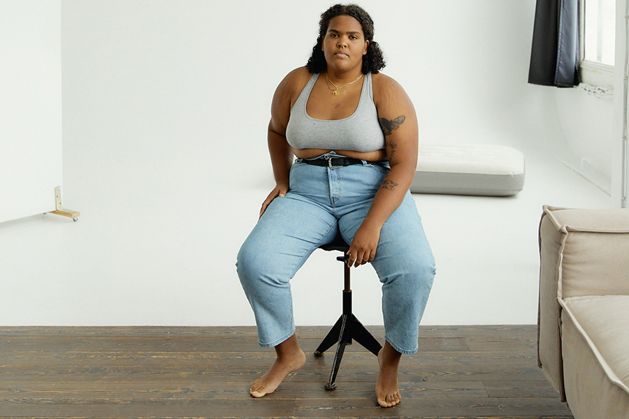 Plus-size lady in a gray sports bra and wide-end denim