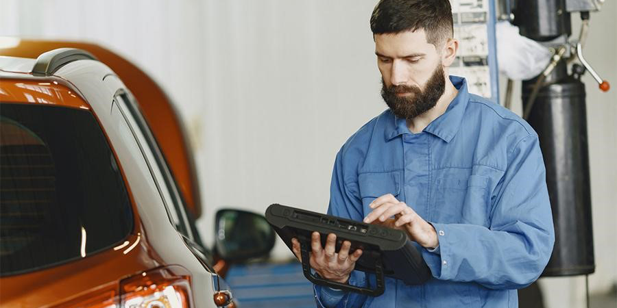Mechanic checking car diagnosis results with an OBD2 scanner
