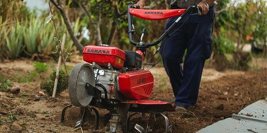 A man using a cultivator for tilling the soil