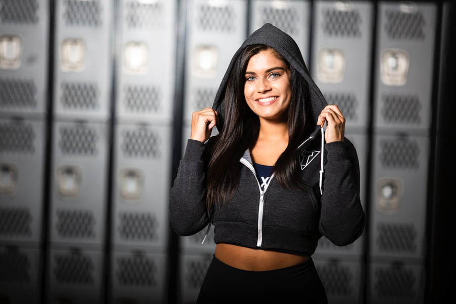 Young woman standing and smiling with a cropped hoodie