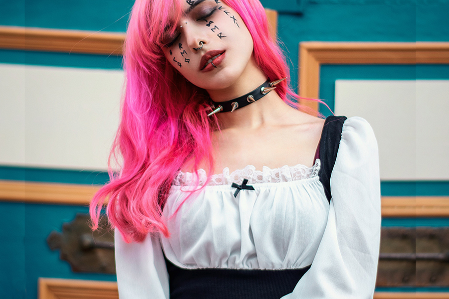 Pink-colored hair lady in black pinafore and white shirt