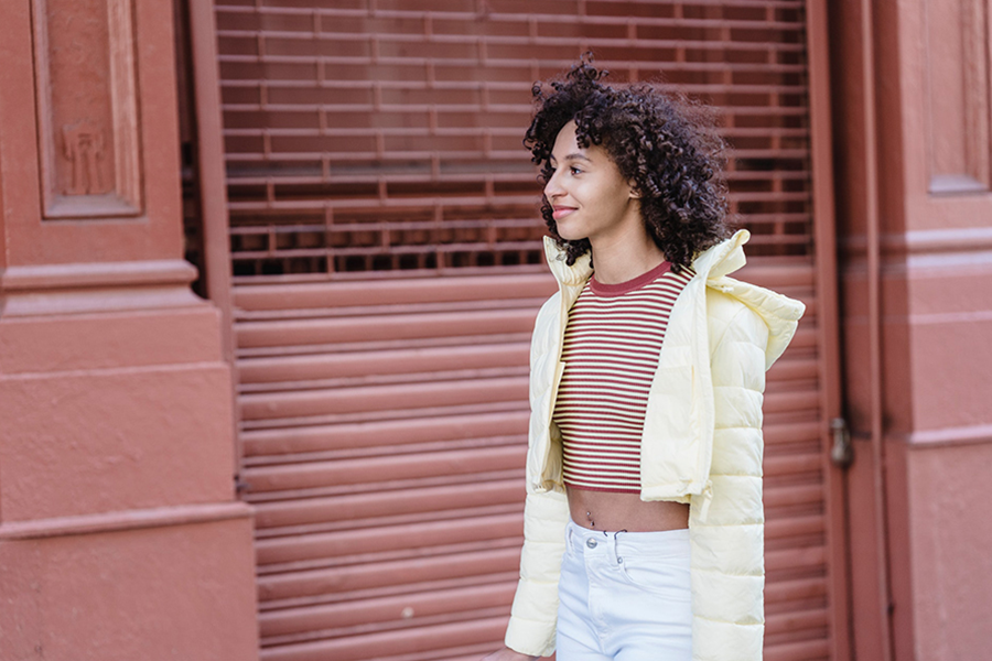 Young lady in crop top layered with yellow padded gilet