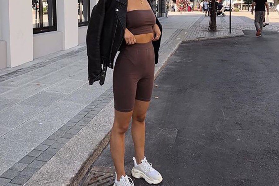 Lady posing with a long brown cycling shorts and jacket
