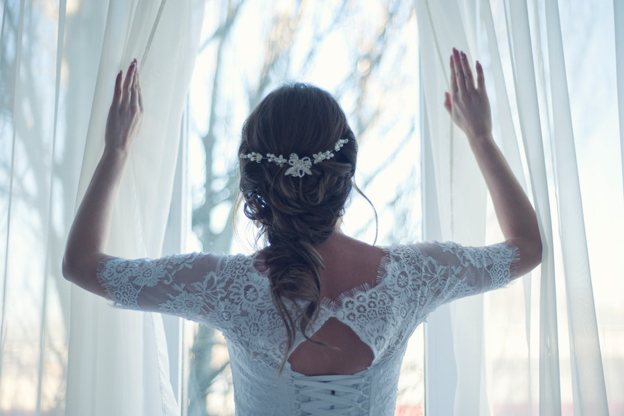 Bride wearing a wedding gown with modern scalloped lace trims