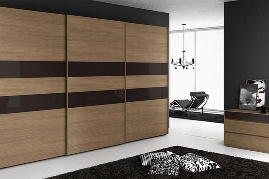A light-brown sliding door wardrobe in a modern bedroom