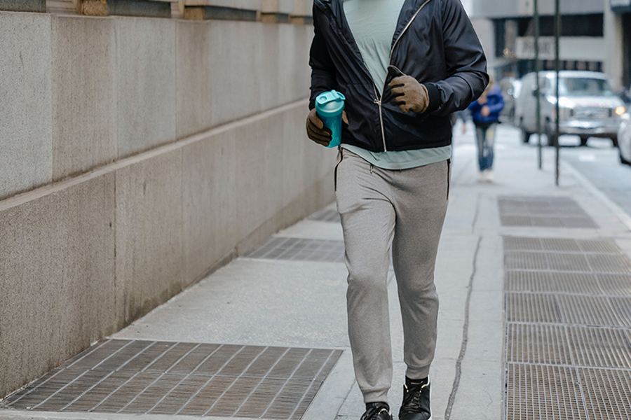Middle-aged man jogging on the street with grey smart joggers