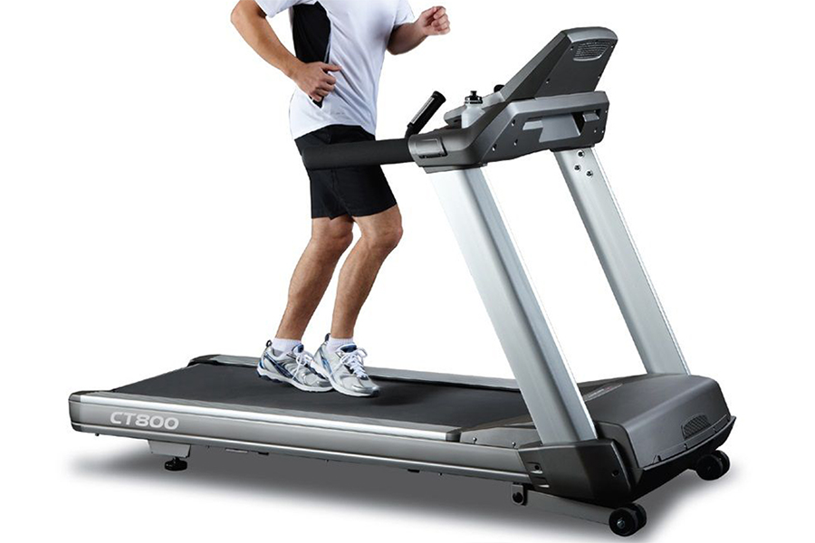 Man in white top jogging on a heavy-duty treadmill