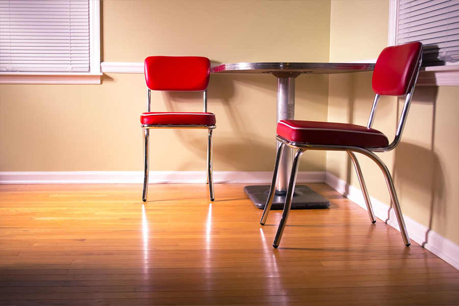 Vinyl wood flooring with a corner table and red chairs