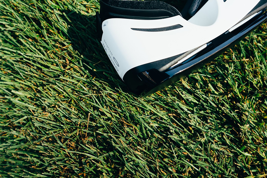White and black VR headset on green grass