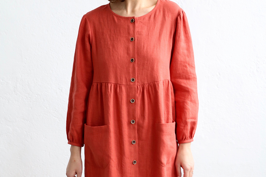 Lady wearing a smoke linen dress with brown rustic buttons