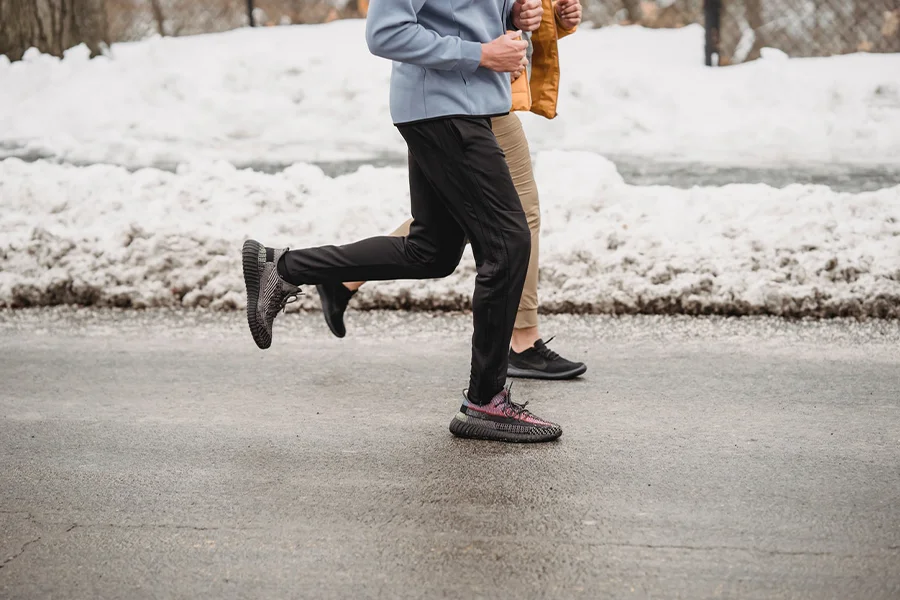 A couple wearing joggers and running