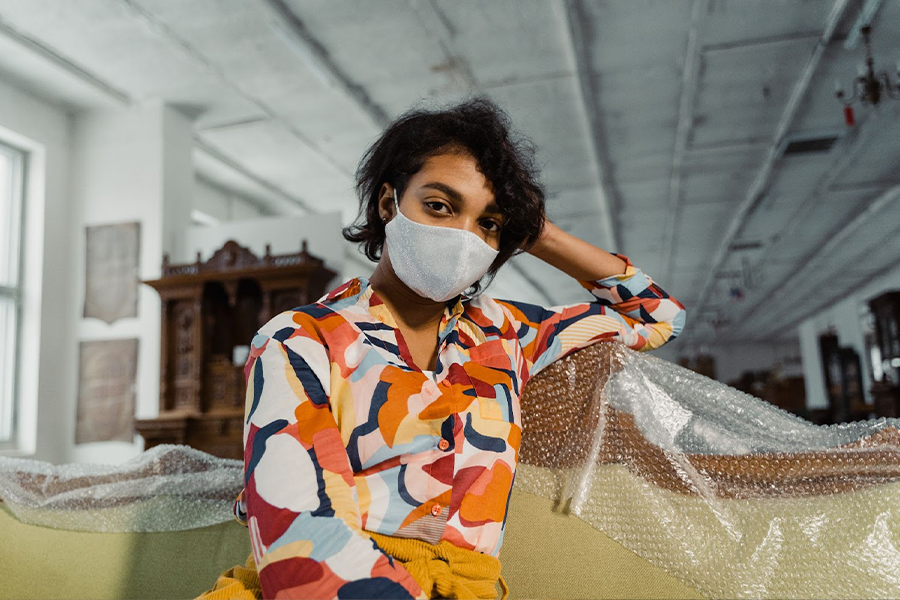 Masked woman in colorful all-over print shirt