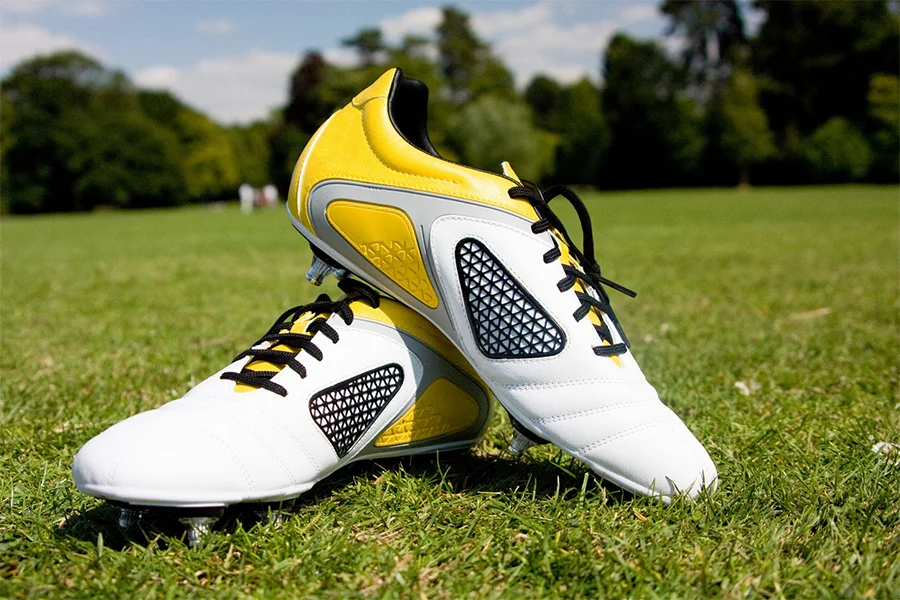 A pair of white and yellow soft gound soccer shoes