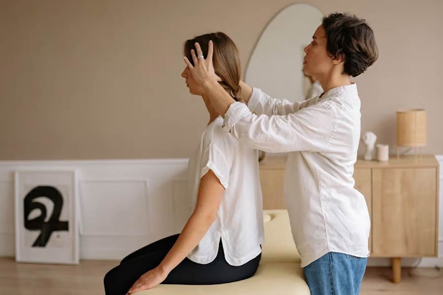 Massage specialist massaging client on a stationary table