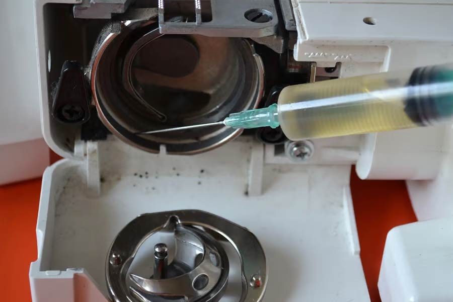 Operator oiling a sewing machine