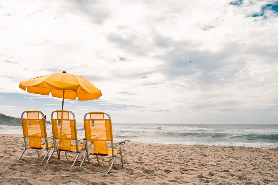 Orange reclining beach chairs with an orange umbrella