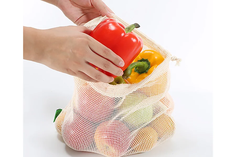 Reusable cotton mesh packaging bag containing groceries