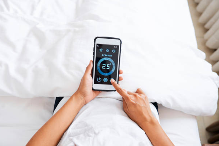 Smartphone with bedroom temperature option in front of a bed