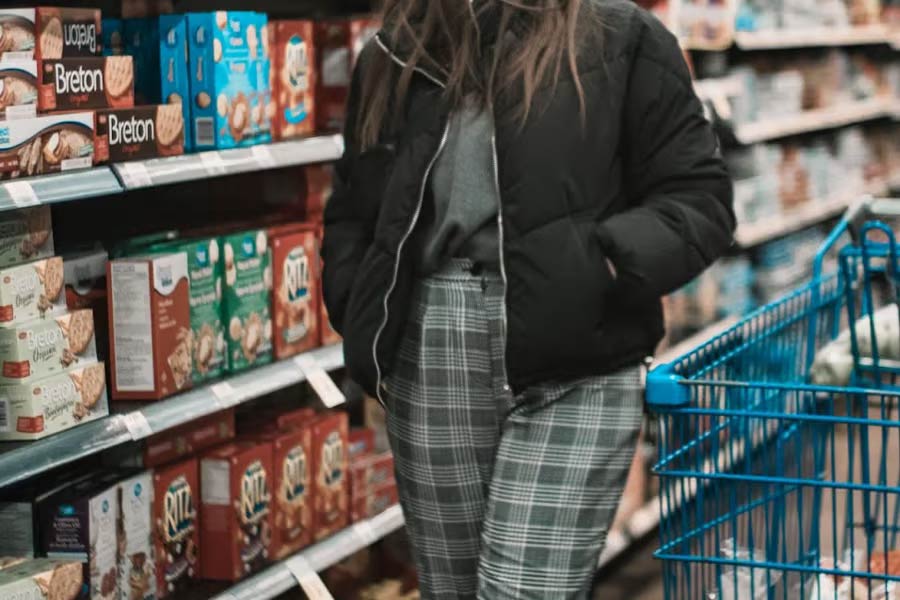 Woman at the supermarket wearing bomber jacket and striped pants