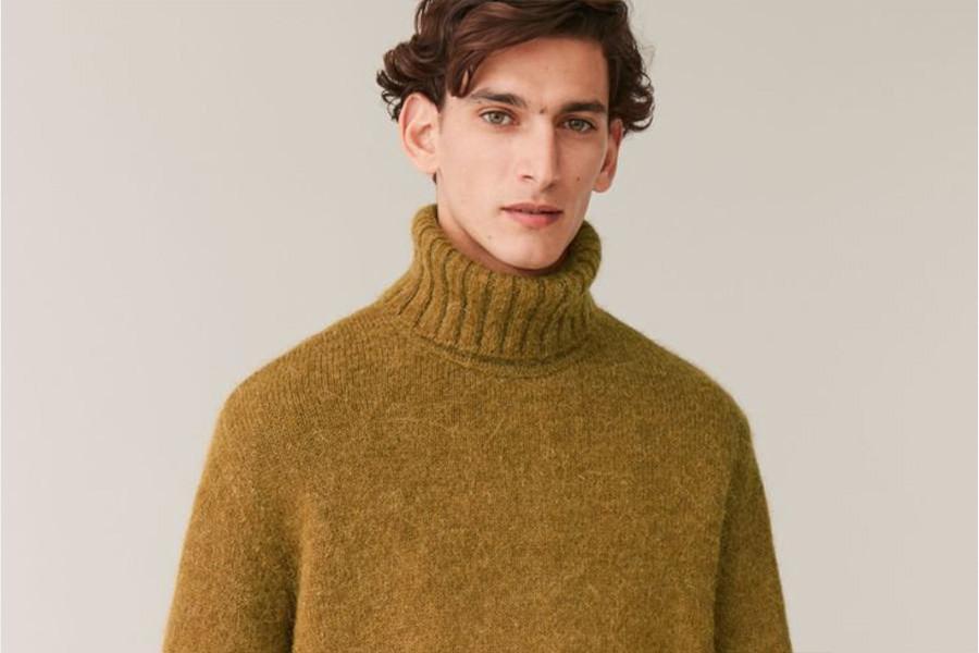 A man wearing a camel roll neck sweater