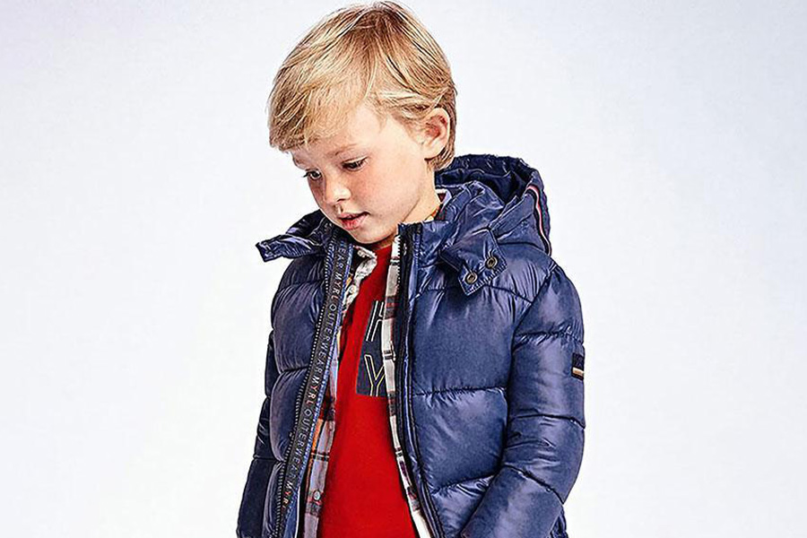 A boy wearing a blue quilted jacket
