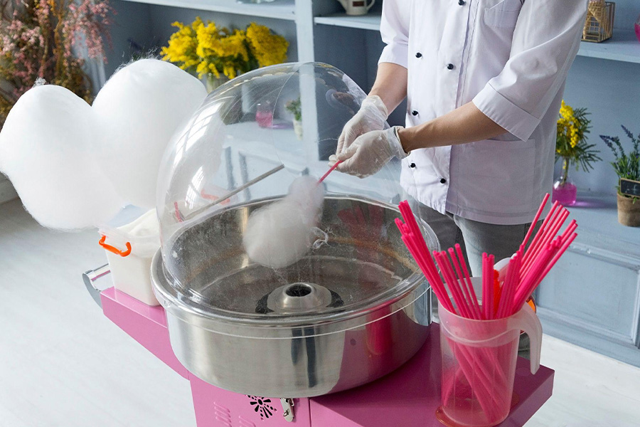 a confectioner carefully bringing cotton candy to life