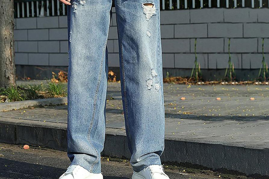 A man wearing baggy blue denim trousers