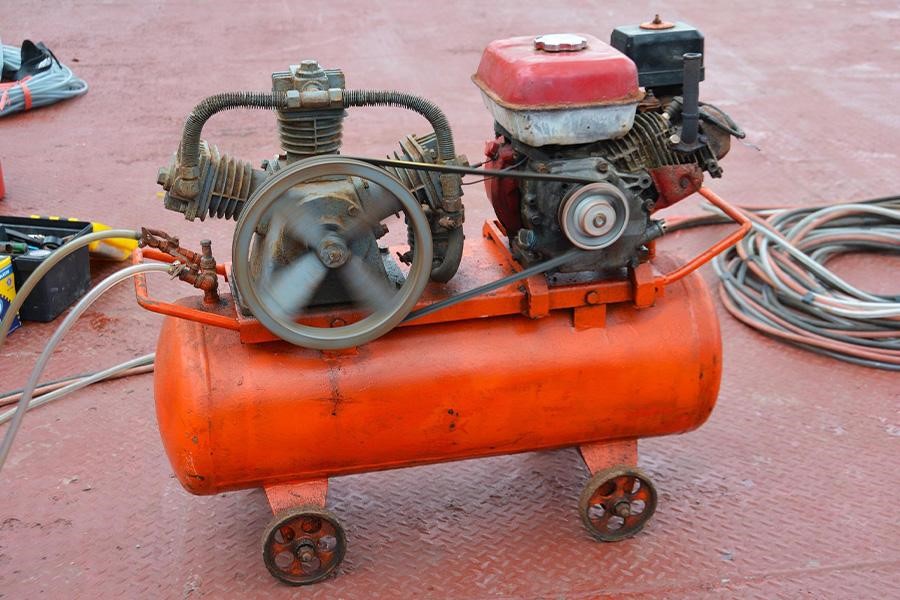A running petrol piston compressor with a storage tank