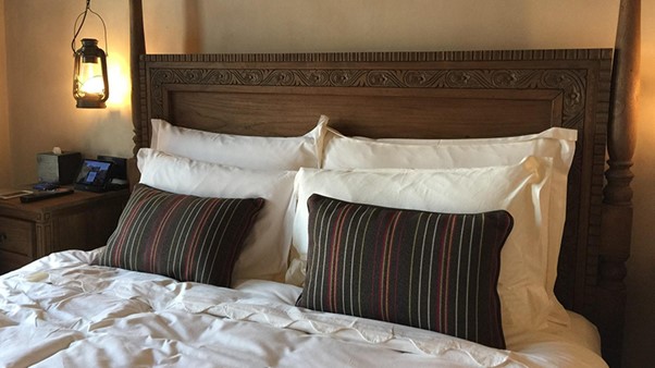 A White Bed With Black Printed Pillows