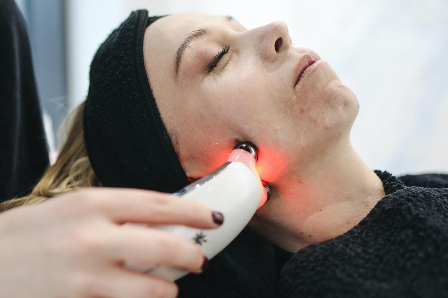 A woman getting facial treatment using a high-tech device