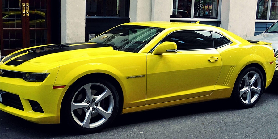A yellow Chevrolet Camaro parked outside