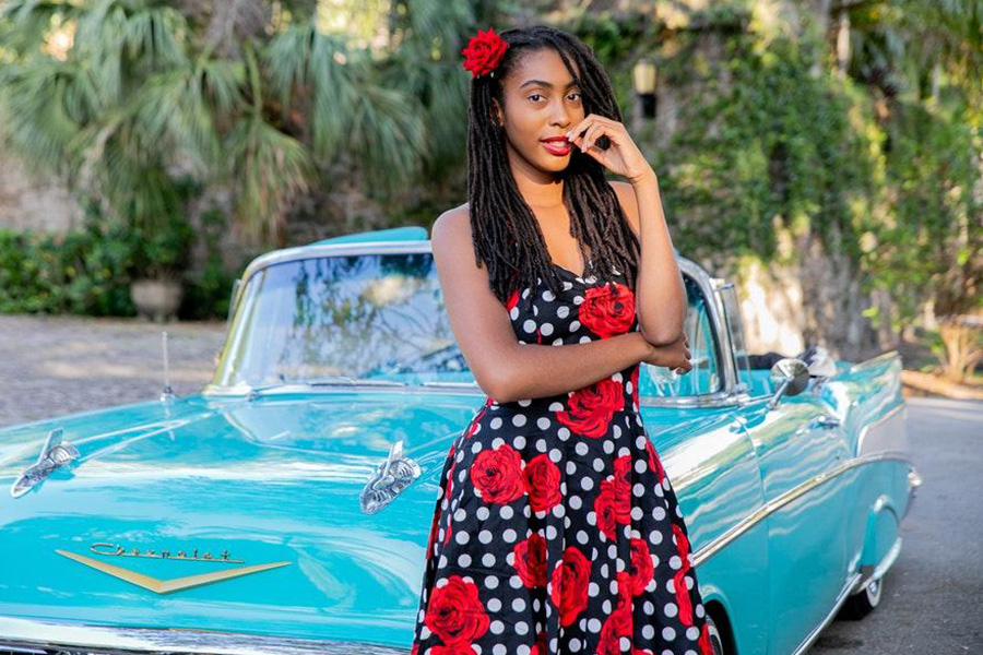 African American model wearing a black and red floral dress