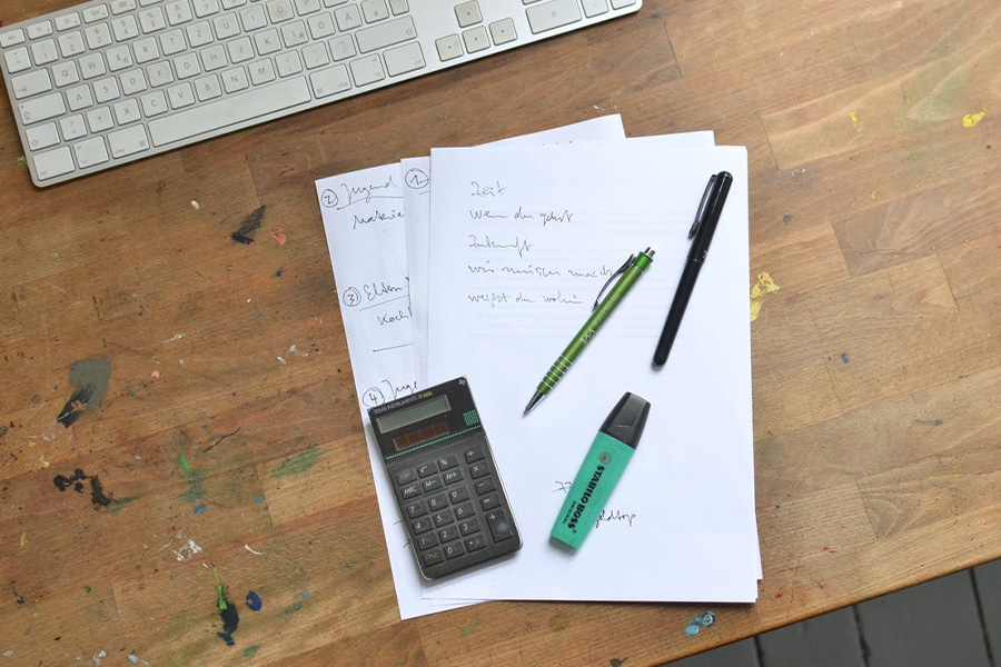 calculator and pen placed on paper