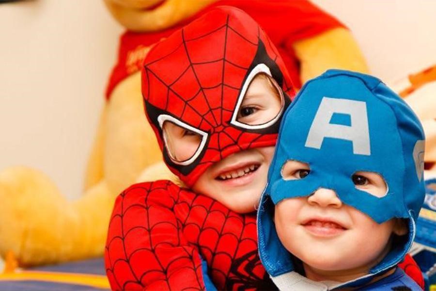 Little boys wearing Spider-man and Captain America costumes