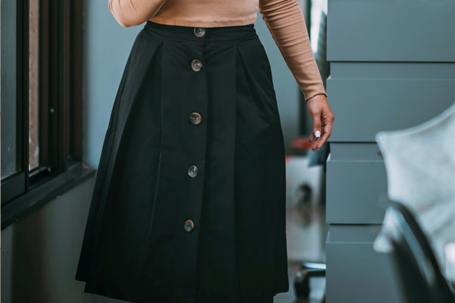 Woman in black button front full skirt for office