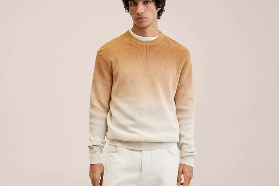 Young man wearing a neutral colored ombre sweater