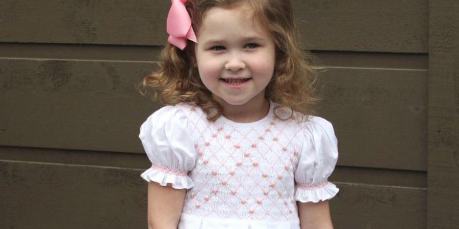 A girl in a pink smocked dress
